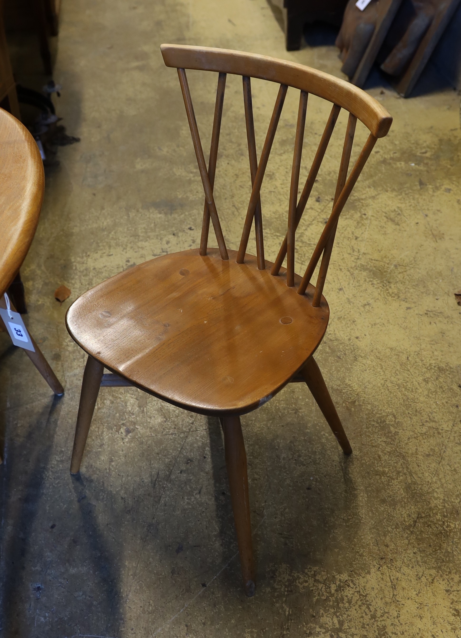 An Ercol elm and beech oval dining table, width 99cm, depth 89cm, height 71cm and four Chiltern chairs